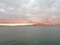 Sunset coloring the hills behind the bay.